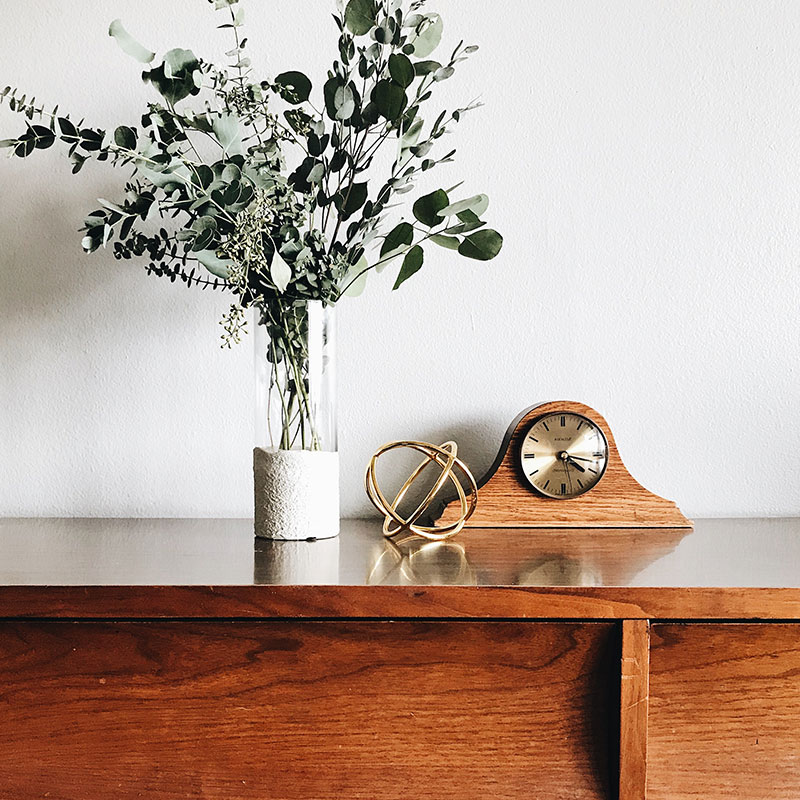 Décoration horloge et plante sur buffet en bois