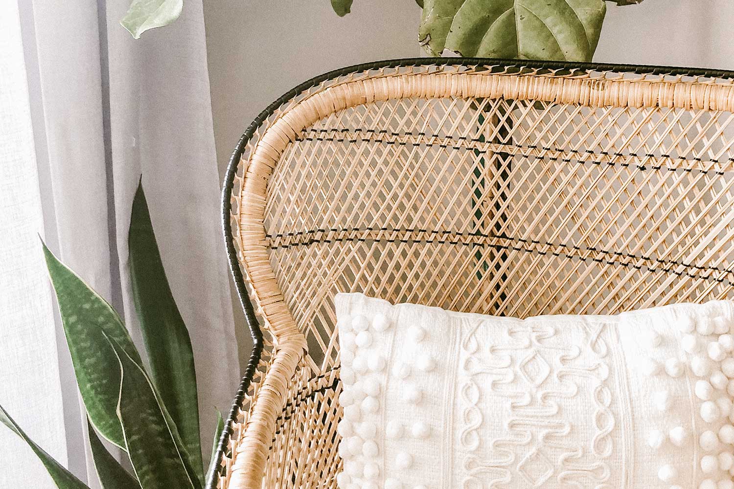 Fauteuil en rotin avec coussin blanc