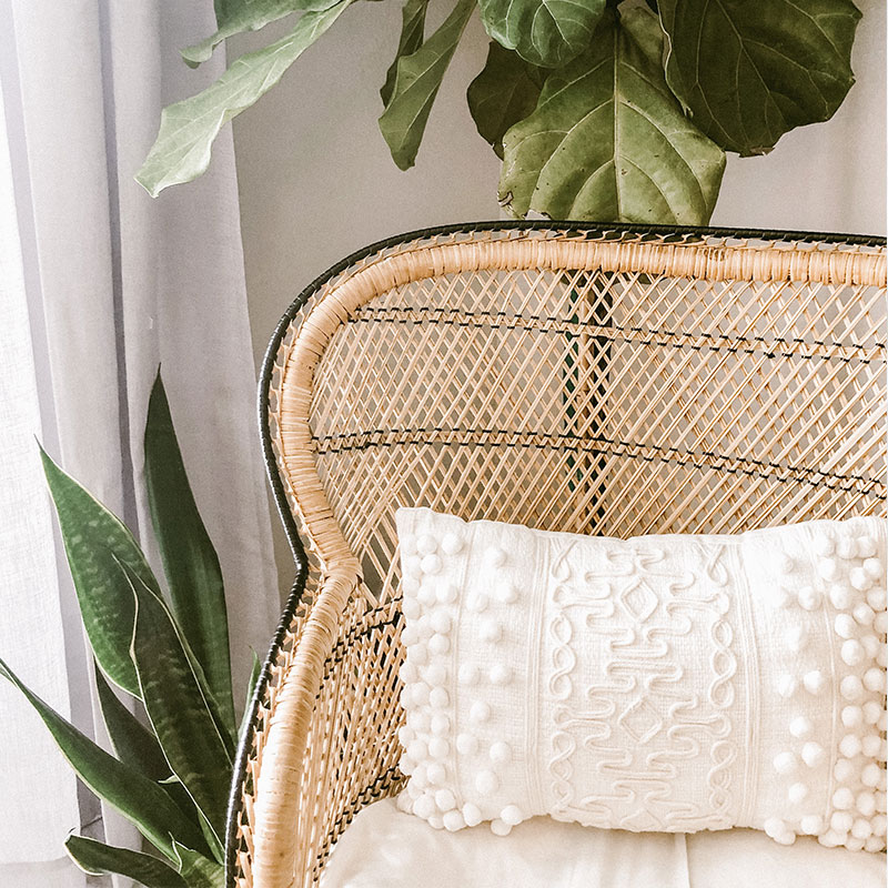 Fauteuil en rotin avec coussin blanc