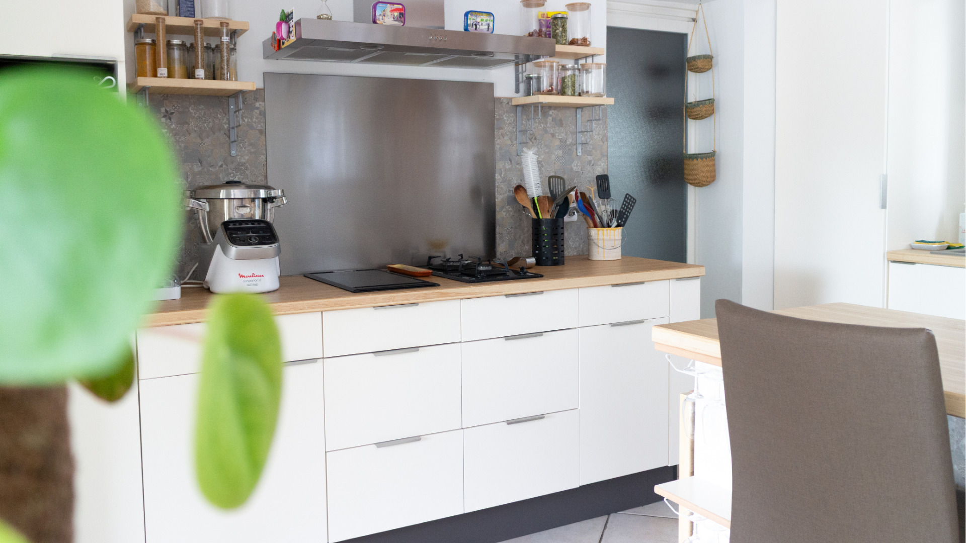 Vue d’ensemble d’un home staging cuisine montrant une cuisine blanche et bois rénovée, ouverte sur le salon et intégrée harmonieusement à l’espace de vie.